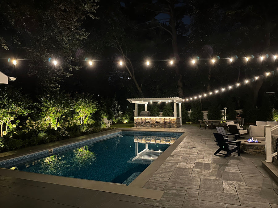 Brilliance bistro string lights illuminating an outdoor gathering area at night