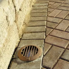 CAST CWLG1CB bronze well light grate installed in pavers